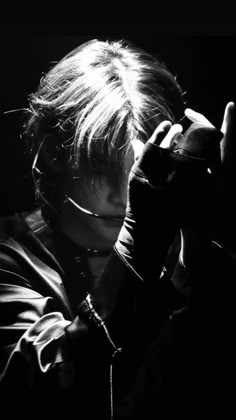 black and white photograph of a man holding his hands up to his face with one hand