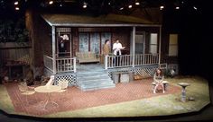 an outdoor stage set with people standing on the porch