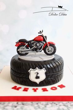 a red motorcycle is on top of a tire with the word love spelled below it