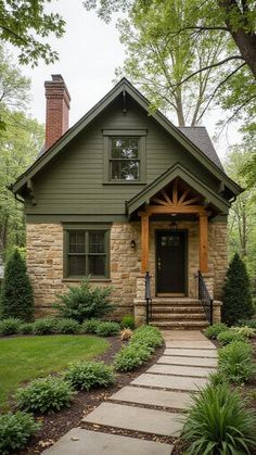 a green house with stone steps leading to the front door