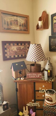 there is a lamp and other items on the table in this room with pictures above it