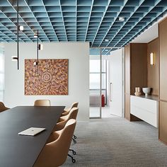 an empty conference room with chairs and a painting on the wall