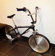 a black and silver bicycle is on the floor next to a wall in a room