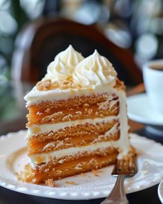 a piece of cake on a plate with a fork and coffee cup in the background
