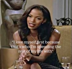 a woman sitting on top of a couch next to wine glasses