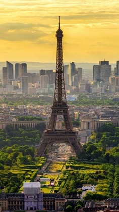 the eiffel tower in paris, france is seen at sunset with other tall buildings behind it