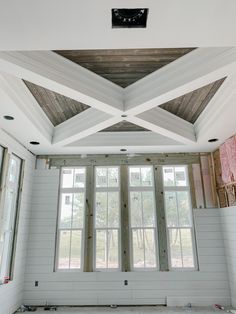 an empty room with wooden beams and windows in the center, all white walls are missing