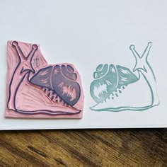 two stamps on top of a piece of paper that has been drawn with colored ink