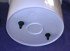 a white object with two black knobs on it's side sitting on a purple surface