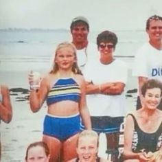 a group of people standing next to each other on a beach