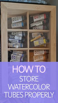 Organized wooden box filled with watercolor paint tubes arranged neatly.