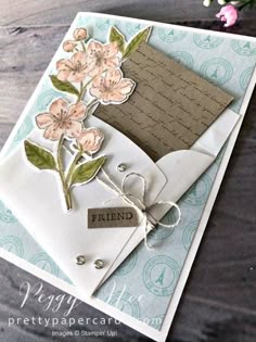 a close up of a greeting card with flowers and a tag on the bottom of it