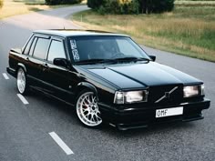 a black car is parked on the side of the road