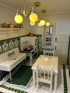 a dollhouse kitchen with white furniture and green tile flooring on the walls, along with yellow lights hanging from the ceiling