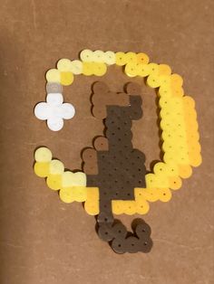 some legos are arranged in the shape of a bear and letter o on a brown surface