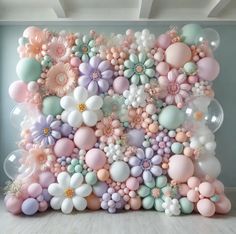 the balloon wall is decorated with pastel colors and flowers