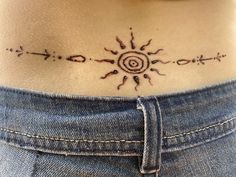a woman's stomach with an intricate sun tattoo on her lower back and side