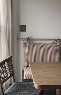 a wooden table with two chairs next to it and a window in the back ground