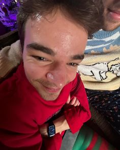 a man wearing a red shirt and tie next to another man