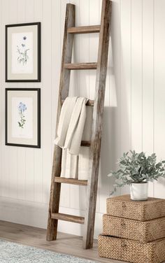 an old wooden ladder leaning against the wall with towels on it and a potted plant next to it