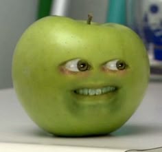 an apple with eyes and a smile on it's face sitting on a table