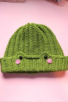 a green knitted hat with eyes on it