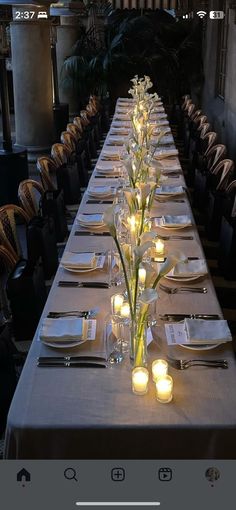 a long table is set with candles and place settings for the dinner guests to enjoy