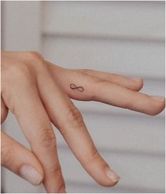a person's hand with a small tattoo on it