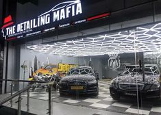 two cars parked in front of a building with the words detailing maffa on it