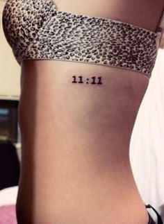 a woman's stomach with the word 11 11 written in small letters on it