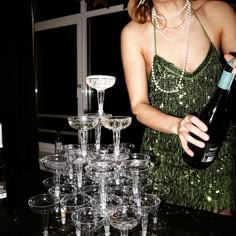 a woman is pouring champagne into wine glasses