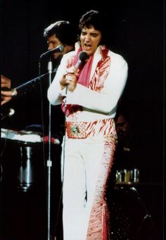 elvis presley singing into a microphone on stage