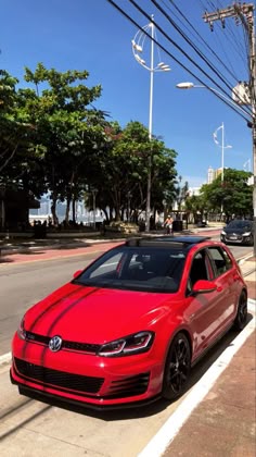 a red car is parked on the side of the road
