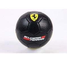 a black soccer ball sitting on top of a white table next to a red and yellow logo