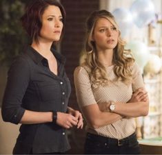 two women standing next to each other in front of a table with gifts on it