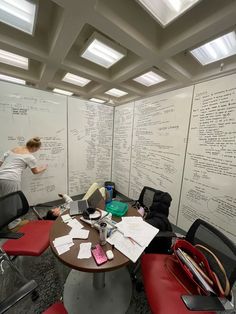 a woman is writing on the wall in an office