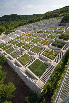 an aerial view of a building with many plants growing on the walls and in the ground