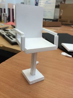 a white chair sitting on top of a wooden table next to a computer keyboard and mouse