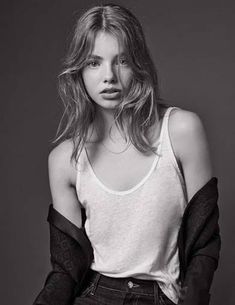 a woman posing in black and white with her hands on her hips, wearing jeans