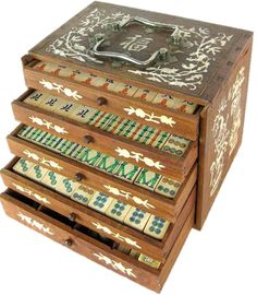 an old wooden jewelry box with decorative designs on the lid and drawers, all painted in different colors