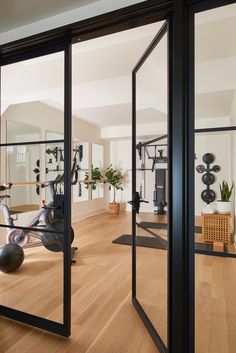 an exercise room with mirrored doors leading to the gym