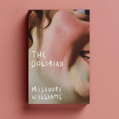 a book with the cover pulled down on a pink background, featuring an image of a woman's face