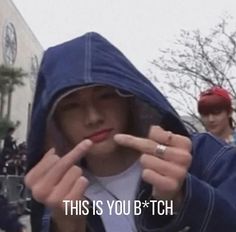 a man in a hoodie holding up two fingers