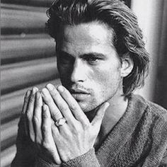 a black and white photo of a man holding his hands together