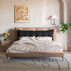 a bedroom with a bed, nightstands and potted plants on the side wall