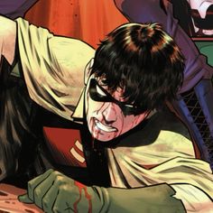 a man laying on the ground with his mouth open and blood dripping from his face