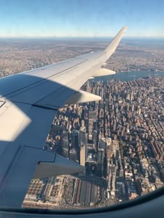 the wing of an airplane flying over a city