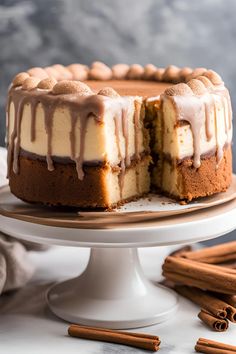 a cake that has been cut in half and is sitting on a plate with cinnamon sticks