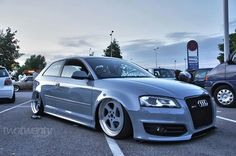 a silver car parked in a parking lot next to other cars