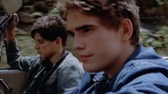 two young men riding in the back of a car